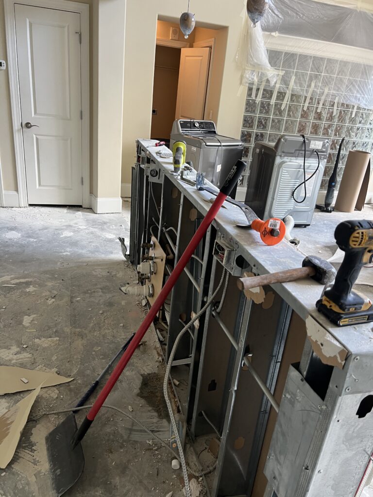 Kitchen demolition in progress with tools and appliances.