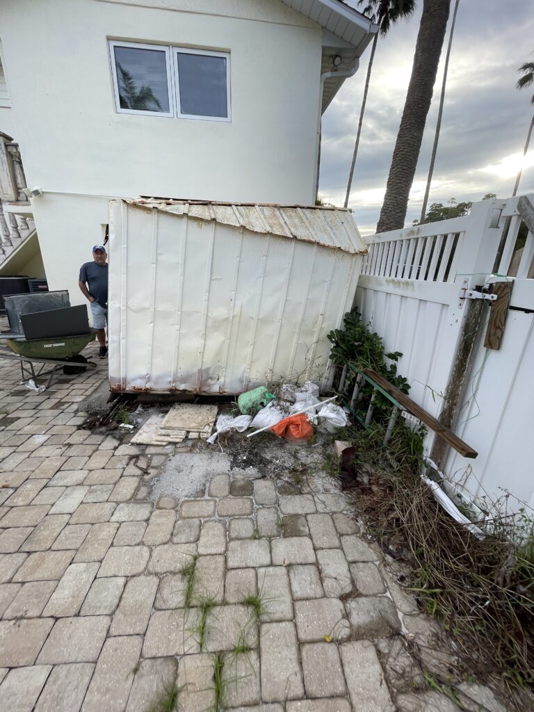 Metal shed beside a house before removal.